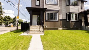 A two-story residential building with a front entrance, a visible mailbox, and a sidewalk leading to the entrance. - ★Bright Modern Suite ★ Netflix - WiFi ✔Long Stays  ★ Clean (Edmonton)