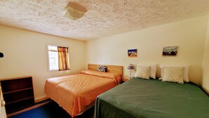 A room with two beds, a window with curtains, a small table, and a wall-mounted lamp. - Sunsplash, Walk to the beach, walk to Main Street (North Myrtle Beach)