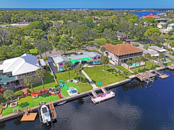 An aerial view of a residential area with houses, a dock, and a marina.