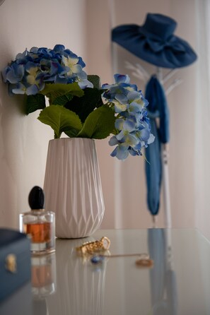 A white vase with blue flowers on a reflective surface. - Nostalgia Corfu Town Apartments (Corfu)