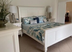 A bedroom with a white bed, floral bedding, and bedside tables with lamps. - Walking distance to the BEACH!!! (Marco Island)