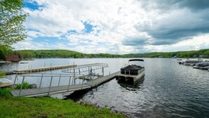 A calm lake with a dock and a boat. - 2nd Floor The Inn at Highland Lake (Winsted)