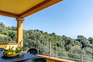 A balcony with a table, chairs, and a bowl of lemons.