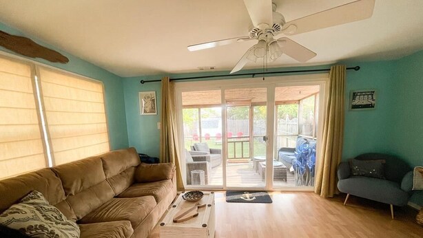 A living room with a brown sofa, a wooden coffee table, and a ceiling fan. - Walk to Washington St. Mall (West Cape May)