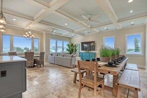 Un'ampia cucina con zona pranzo, grandi finestre e una ventola a soffitto.