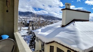 Un balcón con vistas a un pueblo cubierto de nieve y montañas.
