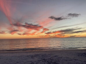 Ein Strand bei Sonnenuntergang mit Blick aufs Meer.