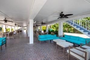 A covered outdoor area with seating, tables, and a staircase. - Tavernier Oceanfront Resort Condo-Pool, Dockage, Kayaks, Onsite Restaurant & Bar (Tavernier)
