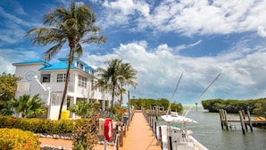 A waterfront property with a dock, boats, and a building with a blue roof.