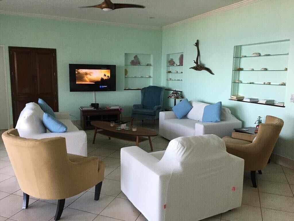 A living room with a television, two sofas, a coffee table, and a ceiling fan.