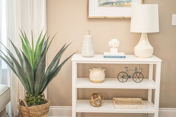 A white shelf with a vase, a bicycle, a wooden box, and a potted plant.