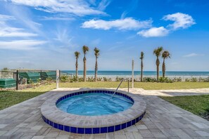Relax by the pool, surrounded by a tiled border and a scenic ocean view.