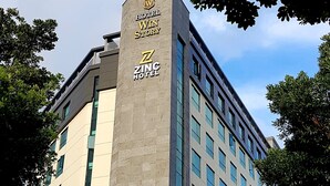 A modern hotel building with a prominent sign for "Hotel Win Story" and "Zinc Hotel". - Hotel ZINC (Seogwipo)