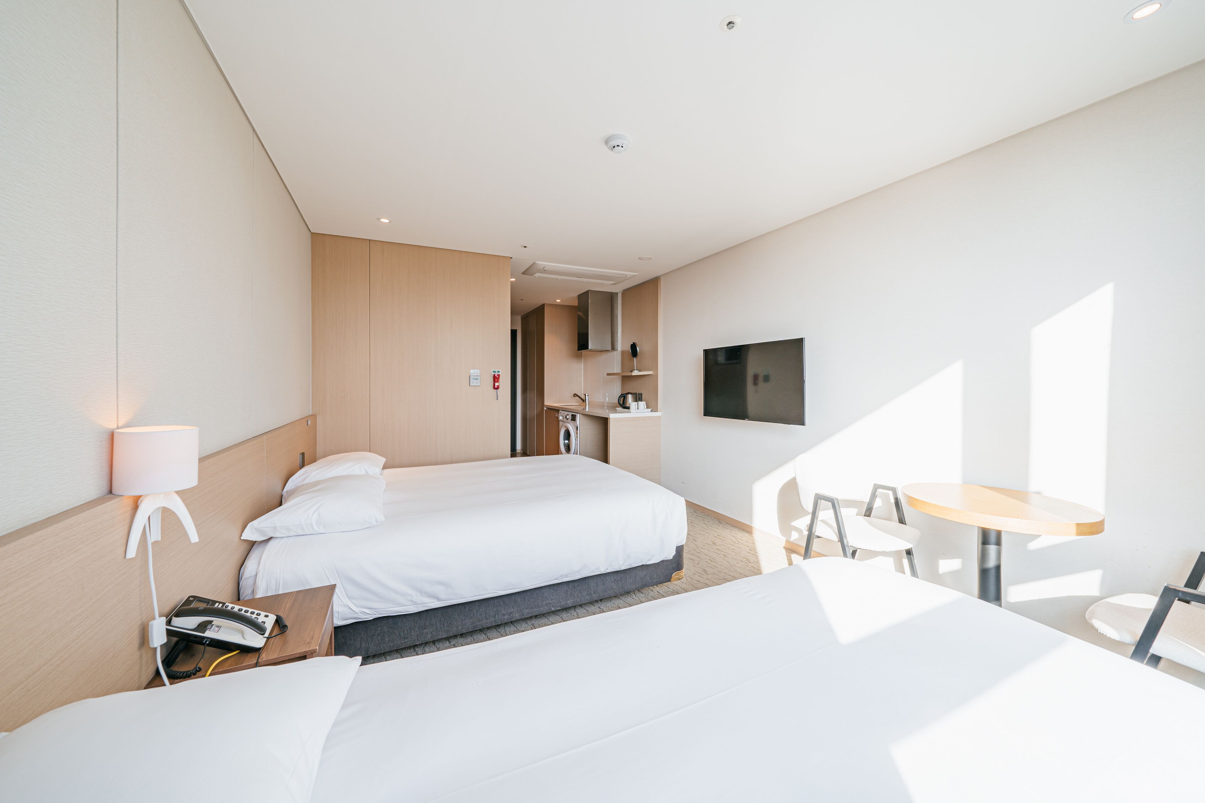 A modern hotel room with a large bed, a desk, and a TV.