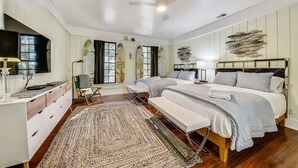 Ein Schlafzimmer mit einem Bett, Nachttischen, einem Schreibtisch und einem Stuhl.