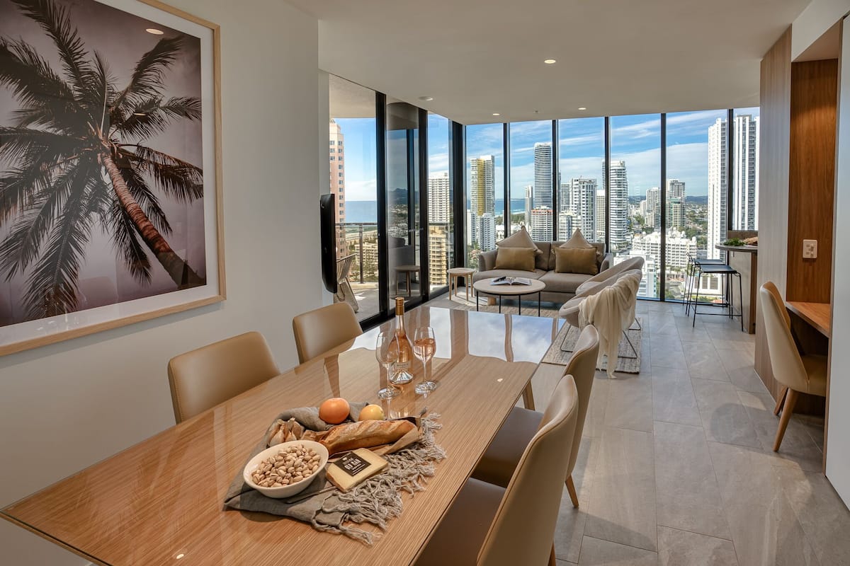 A modern dining area with a large table, chairs, and a city view.