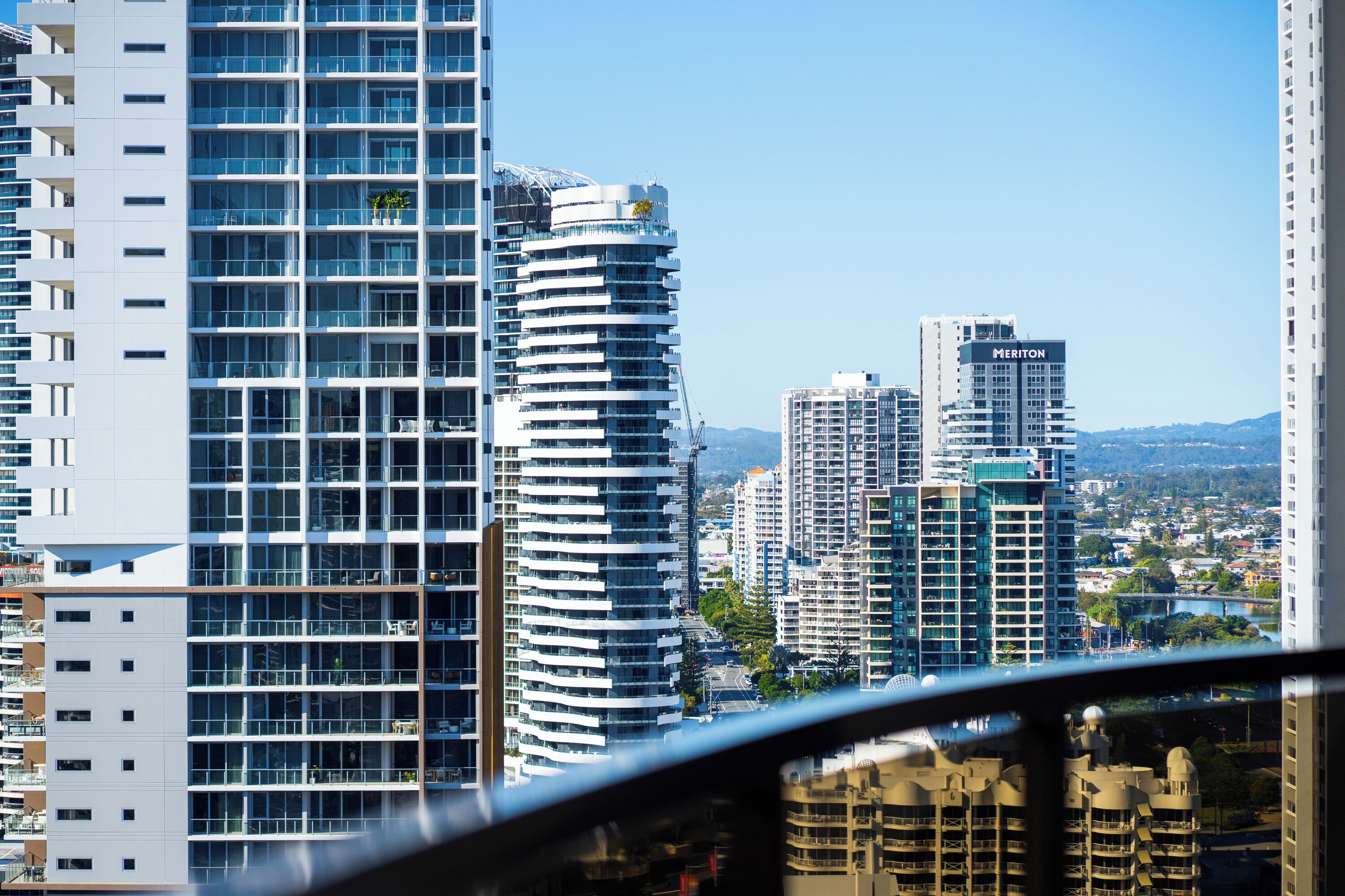 A high-rise building with a modern architectural design, featuring multiple balconies and large windows.