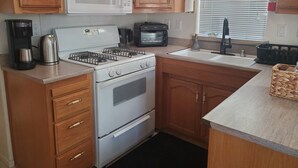 Eine Küche mit Holzausstattung, einem weißen Herd, einer Mikrowelle, einem Toaster und einer Kaffeemaschine.