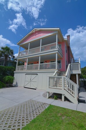 A two-story house with a balcony on the second floor, a garage, and a covered front porch. - Top Floor Suite of classic 1940's Beach Cottage with porch & partial ocean view. (Wrightsville Beach)
