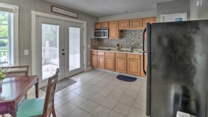 A kitchen with wooden cabinets, a black refrigerator, and a microwave. - Trout Fishing Retreat on White River w/ Patio (Lakeview)