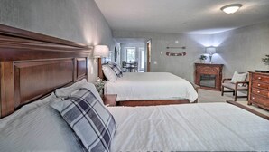 A bedroom with two beds, a dresser, a chair, and a lamp. - Trout Fishing Retreat on White River w/ Patio (Lakeview)