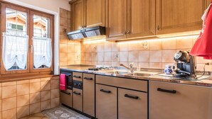 A kitchen with wooden cabinets, a stainless steel sink, and a coffee maker. - Apartment "Casa Sicina Albina" with Mountain View, Wi-Fi & Balcony (Valfloriana Sicina)