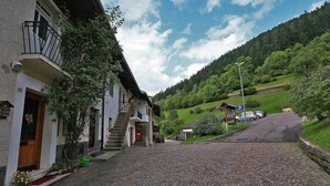 A cobblestone street leading to a building with a wooden door and a balcony. - Apartment "Casa Sicina Albina" with Mountain View, Wi-Fi & Balcony (Valfloriana Sicina)
