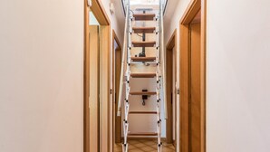 A narrow hallway with a wooden door on the right and a white wall on the left. - Apartment "Casa Sicina Albina" with Mountain View, Wi-Fi & Balcony (Valfloriana Sicina)