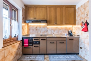 Una cocina funcional con gabinetes de madera, estufa y lavavajillas.