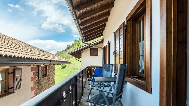 A balcony with a view of a green landscape, a wooden railing, and a table with chairs. - Apartment "Casa Sicina Albina" with Mountain View, Wi-Fi & Balcony (Valfloriana Sicina)