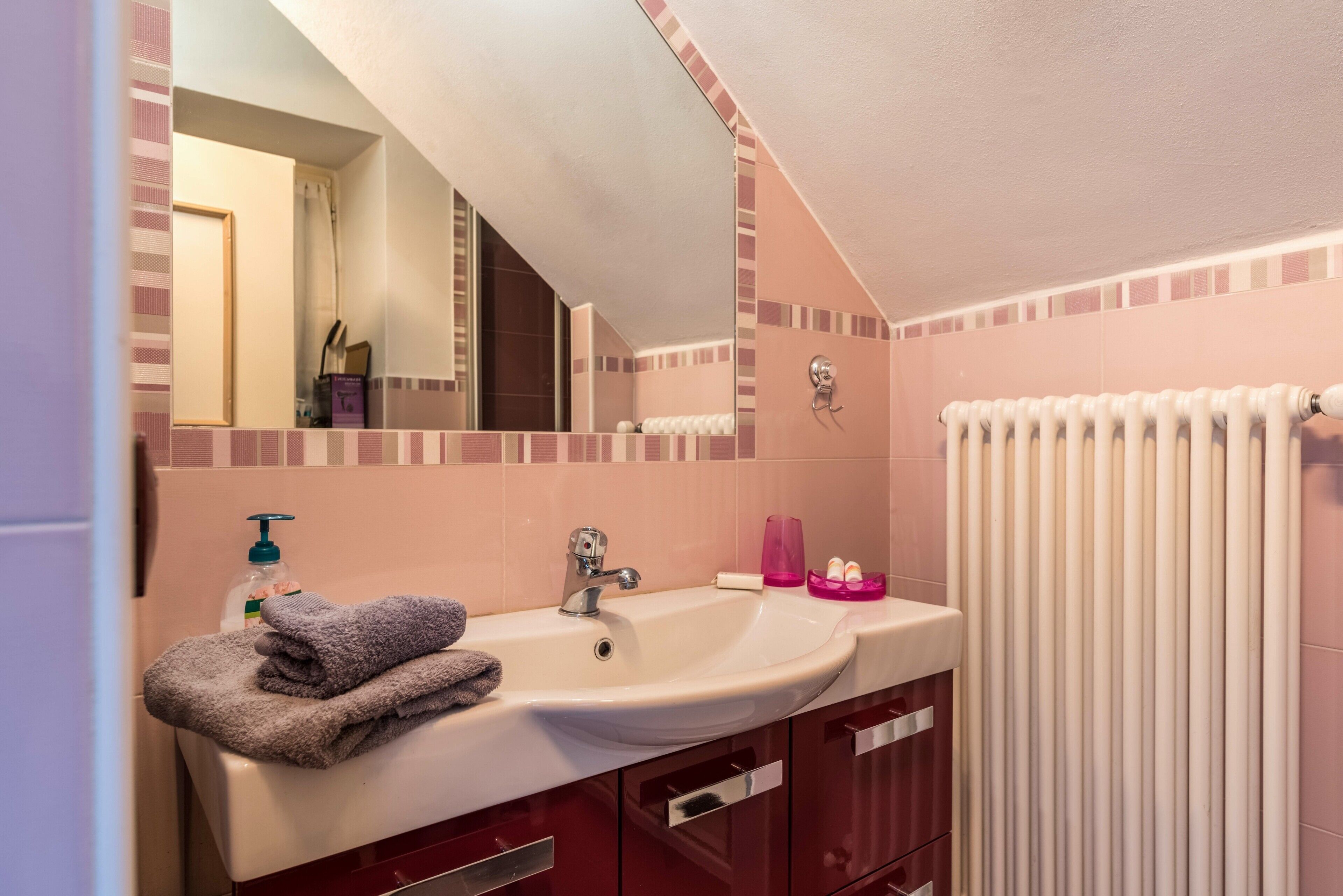 Ein Badezimmer mit Waschbecken, Spiegel und Handtuchhalter.
