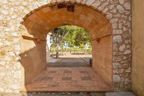 An arched stone structure with a paved pathway leading through it.