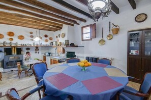 Un'area pranzo con un tavolo rotondo, sedie e un lampadario.