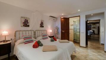 Habitación doble con dos camas, lámparas de noche, un armario, un espejo y zona de ducha.