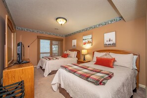 A hotel room with two beds, a desk with a computer, a lamp, and artwork on the walls. - Cozy Cove Retreat w/ Deck & Fireplace (McHenry)