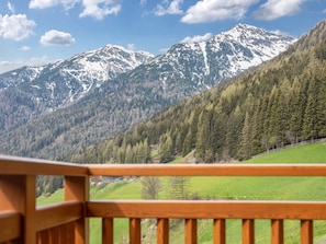 Un paysage de montagne avec une balustrade en bois sur un balcon.