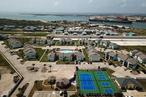 A residential area with houses, a swimming pool, and a tennis court. - 1st Floor, Near Ferry ,Shared Pool, Golf Cart Access (Port Aransas)