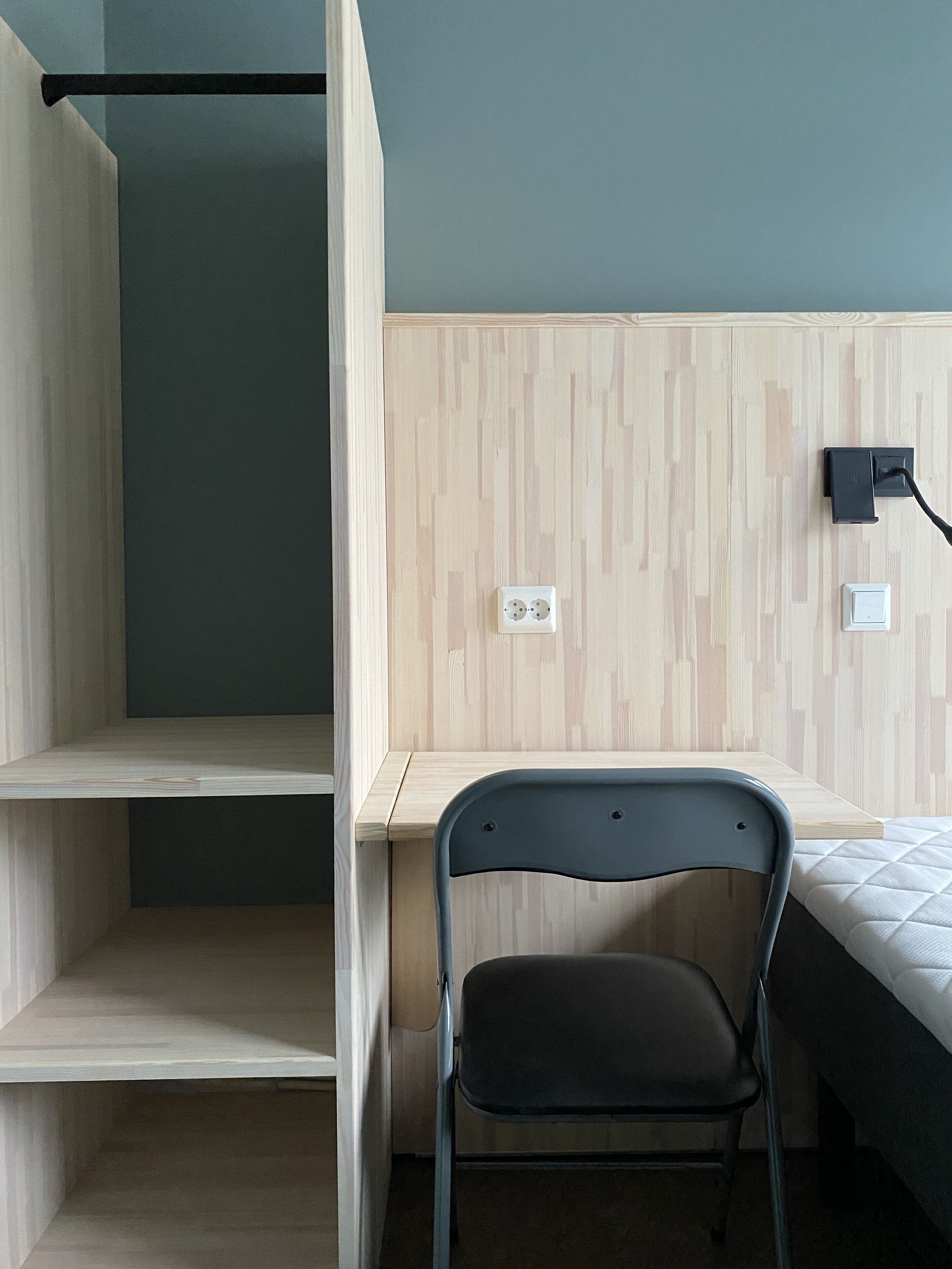 A room with a bunk bed, a desk, a chair, and a bed.