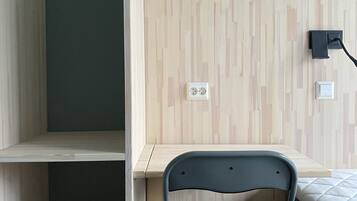 A room with a bunk bed, a desk, a chair, and a bed.