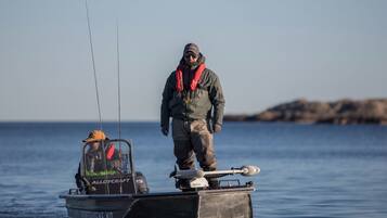 Uma pessoa em um barco segurando uma vara de pesca.