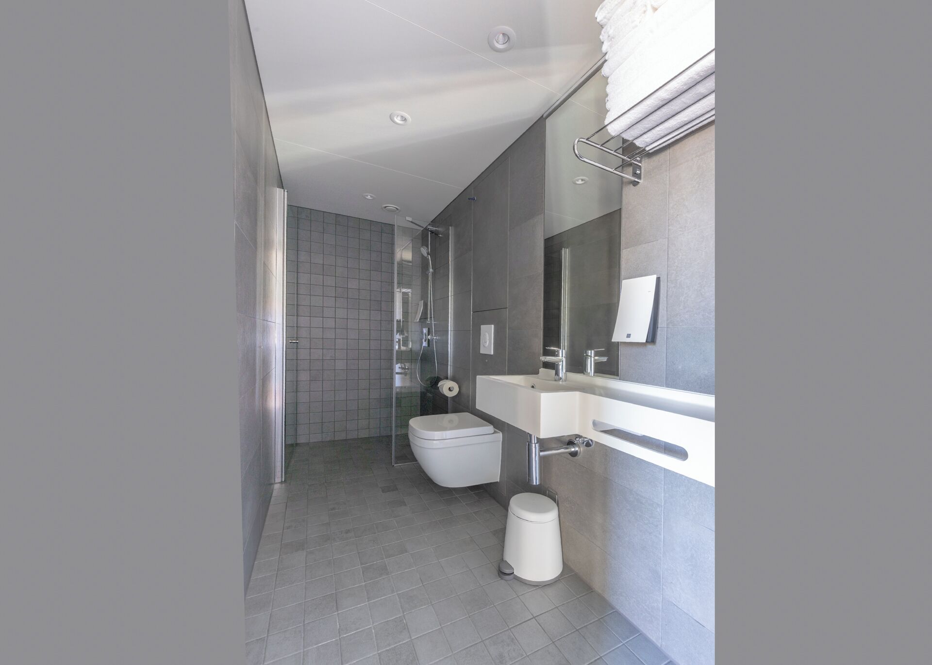 A modern bathroom with a toilet, sink, and shower.