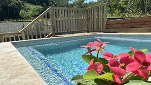 A swimming pool with clear blue water, surrounded by a wooden deck and a metal fence. - 6 min walk to beach / private pool/ AC (Cabo Rojo)