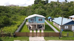 A two-story house with a blue exterior and a covered patio. - 6 min walk to beach / private pool/ AC (Cabo Rojo)