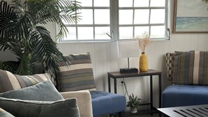 A living room with a sofa, a coffee table, a side table, and a potted plant. - 6 min walk to beach / private pool/ AC (Cabo Rojo)