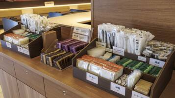 Présentation de différents produits à base de thé et de divers articles liés au café dans un magasin.