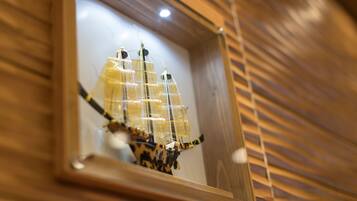 A framed model ship in a wooden display case.