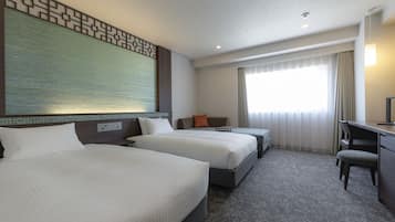 A hotel room with two beds, a desk, and a chair.