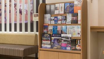 A wooden information kiosk with brochures and maps in a hotel lobby.