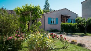 A house with a garden, a pergola, and a satellite dish.