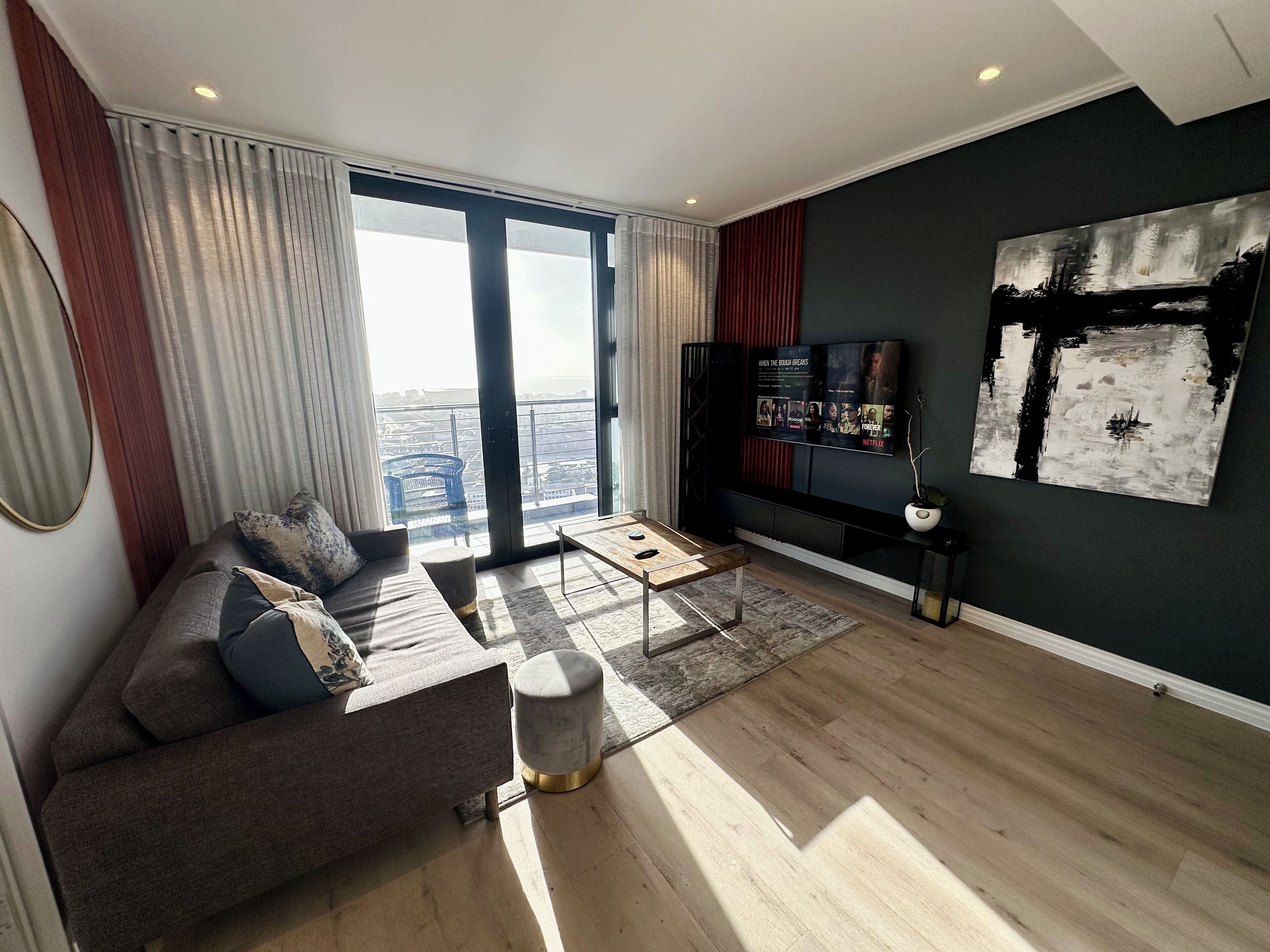Un salon moderne avec un canapé, une table basse et un grand téléviseur.